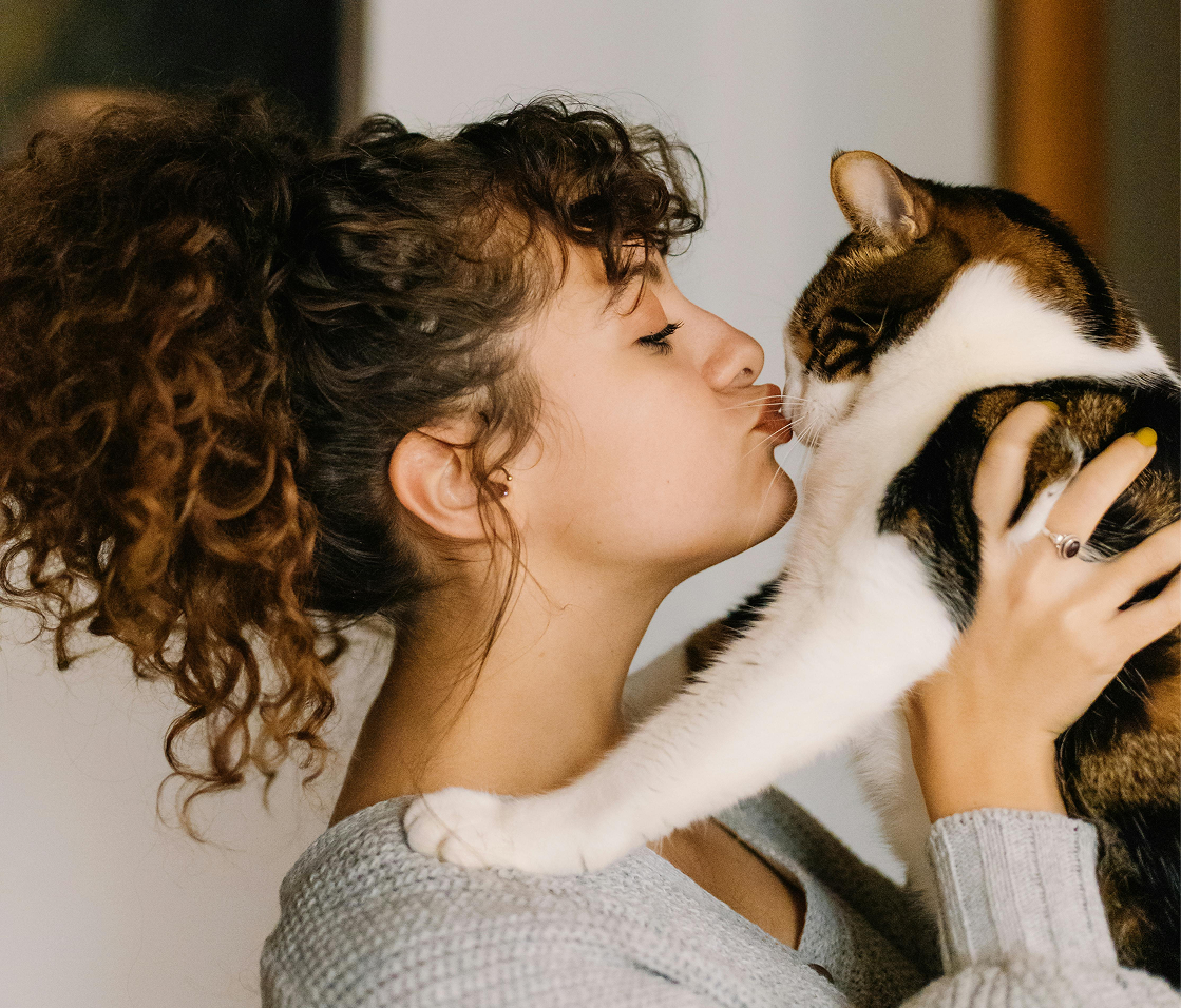 Mulher beijando um gato
